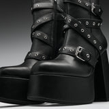Black leather platform ankle boots with multiple wraparound straps, silver-tone eyelets, and chunky block heels, shown in a studio close-up.