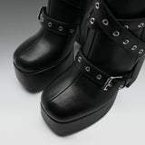 Black platform boots with multiple decorative straps, silver-tone grommets, and buckles, shown in a close-up studio shot.