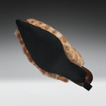 A black pointed-toe shoe with a brown and beige faux-fur trim, shown from a side angle against a dark gray gradient background.