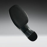 A close-up studio shot of the underside of a black athletic shoe, showing the textured outsole, heel, and a small section of the metallic outsole edge against a gray gradient background.