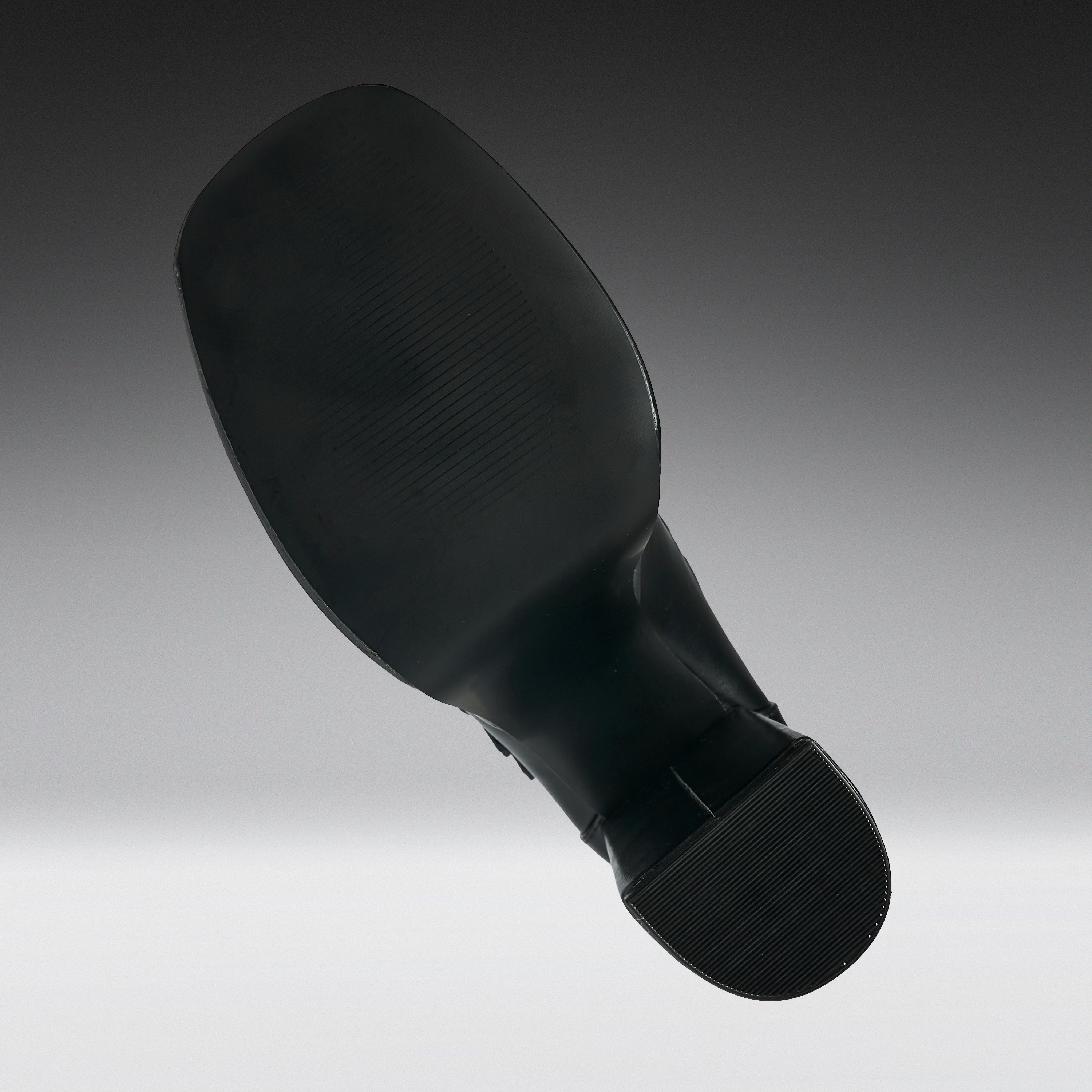 A black shoe sole shown floating against a gradient gray background.