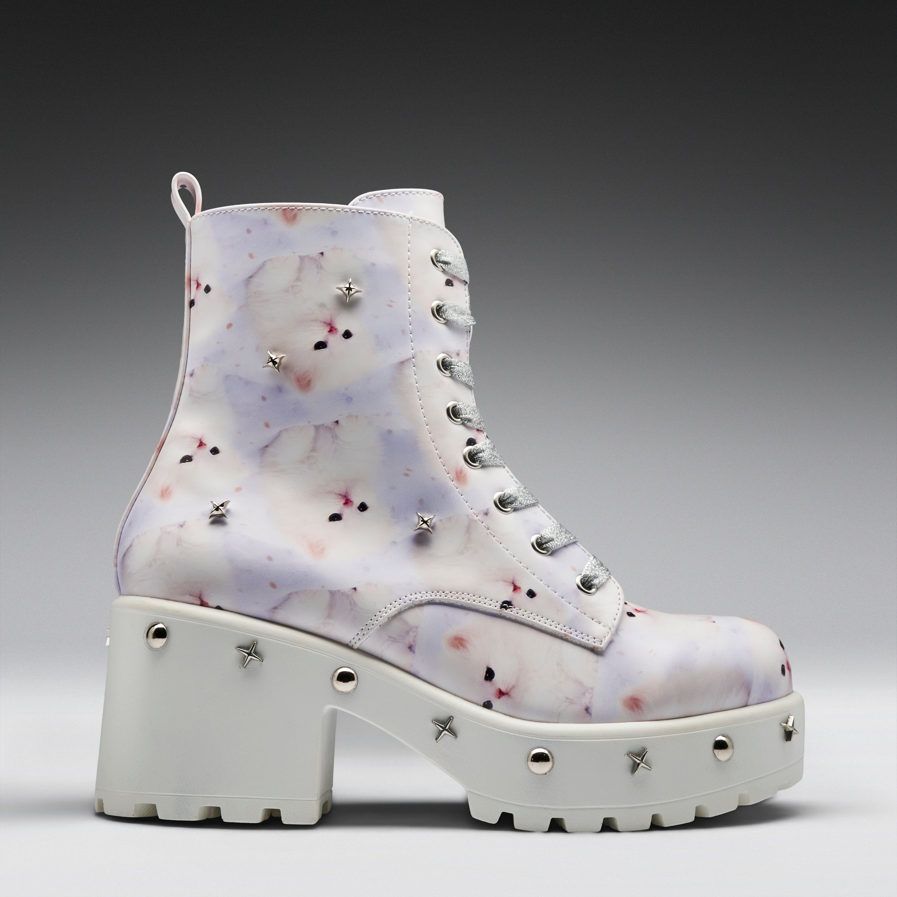 A high-top platform boot with a white base, decorated with a light purple and pink watercolor-style floral pattern, and embellished with silver star and round studs.