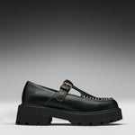 A single black leather Mary Jane loafer with a chunky lug sole, a gold buckle strap, and decorative gold stitching on the toe, shown against a dark gray gradient background.