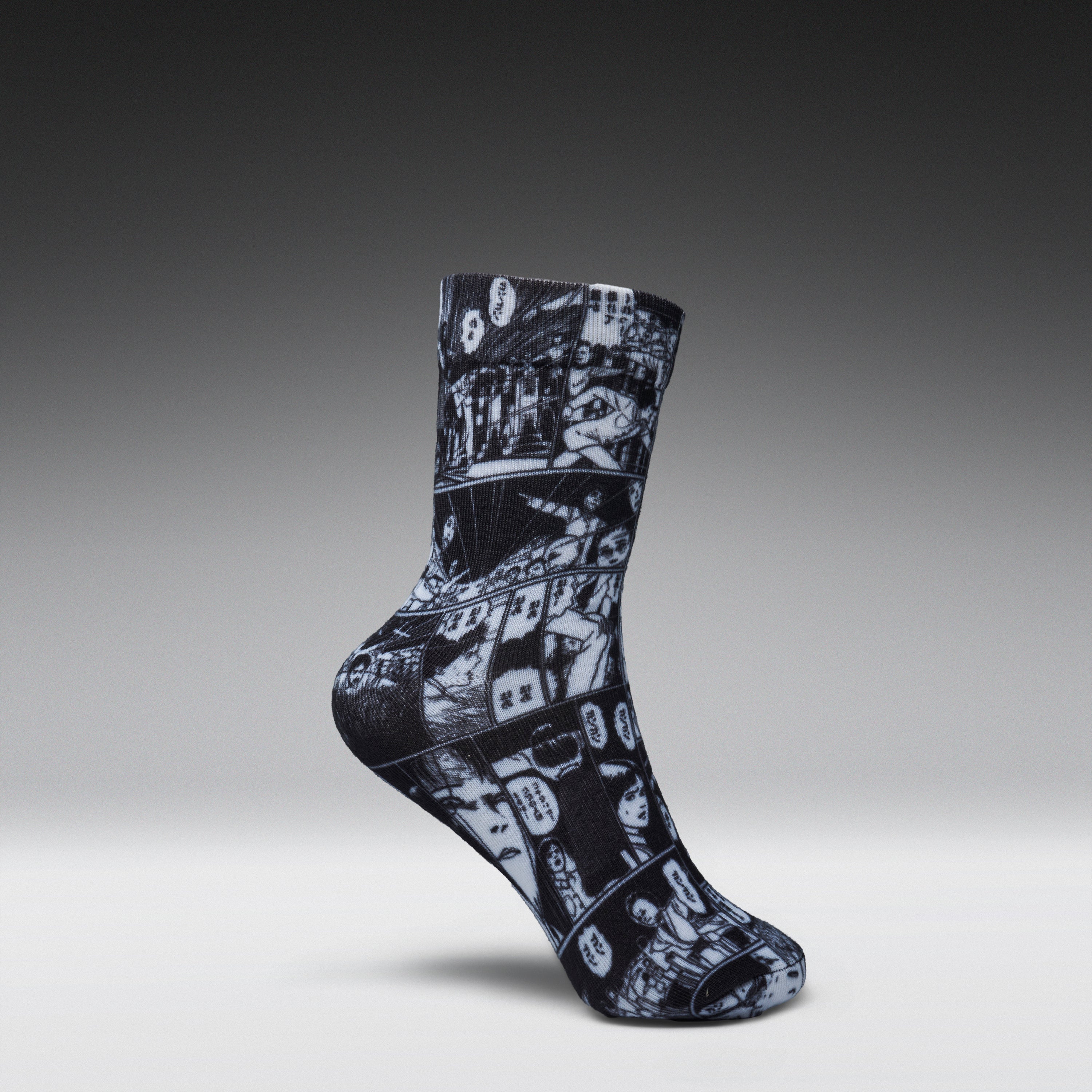 A single crew sock with a black and white comic book panel print, shown in a floating pose against a dark gray gradient background.