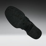 A close-up of a black textured shoe sole, shown floating against a gradient gray background.