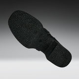 A close-up of a black textured shoe sole, shown floating against a gradient gray background.