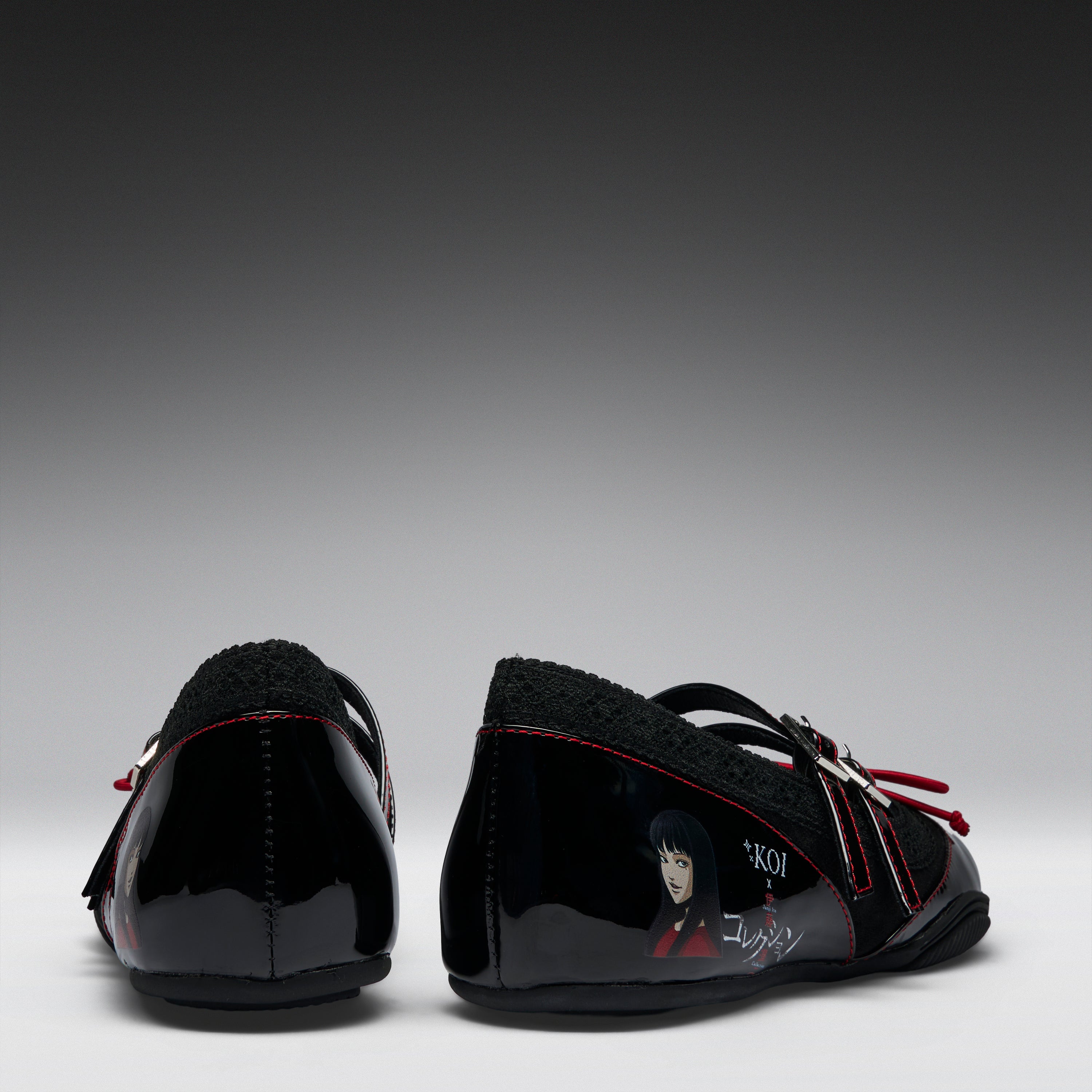 A pair of black patent leather Mary Jane shoes with black fleece lining, red contrast stitching, and character graphics on the sides, shown from the back against a gradient gray background.