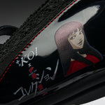 Close-up of a black sneaker featuring a glossy side panel with red stitching, a stylized anime character illustration, and white and red text reading 'KOI x Just for Coaster Collection'.
