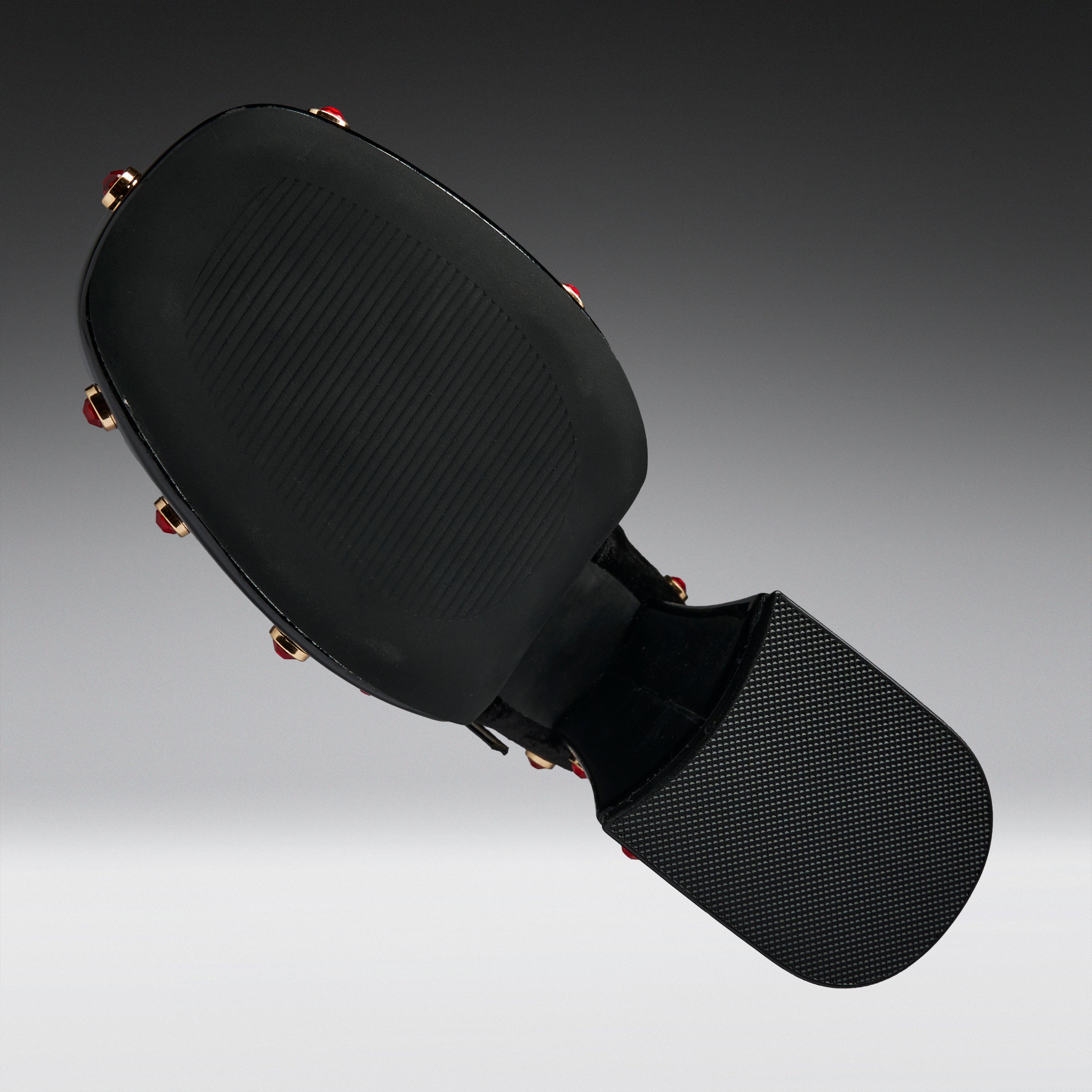 Black martial arts kicking pad with a textured head and a padded striking surface, shown floating against a dark gray gradient background.