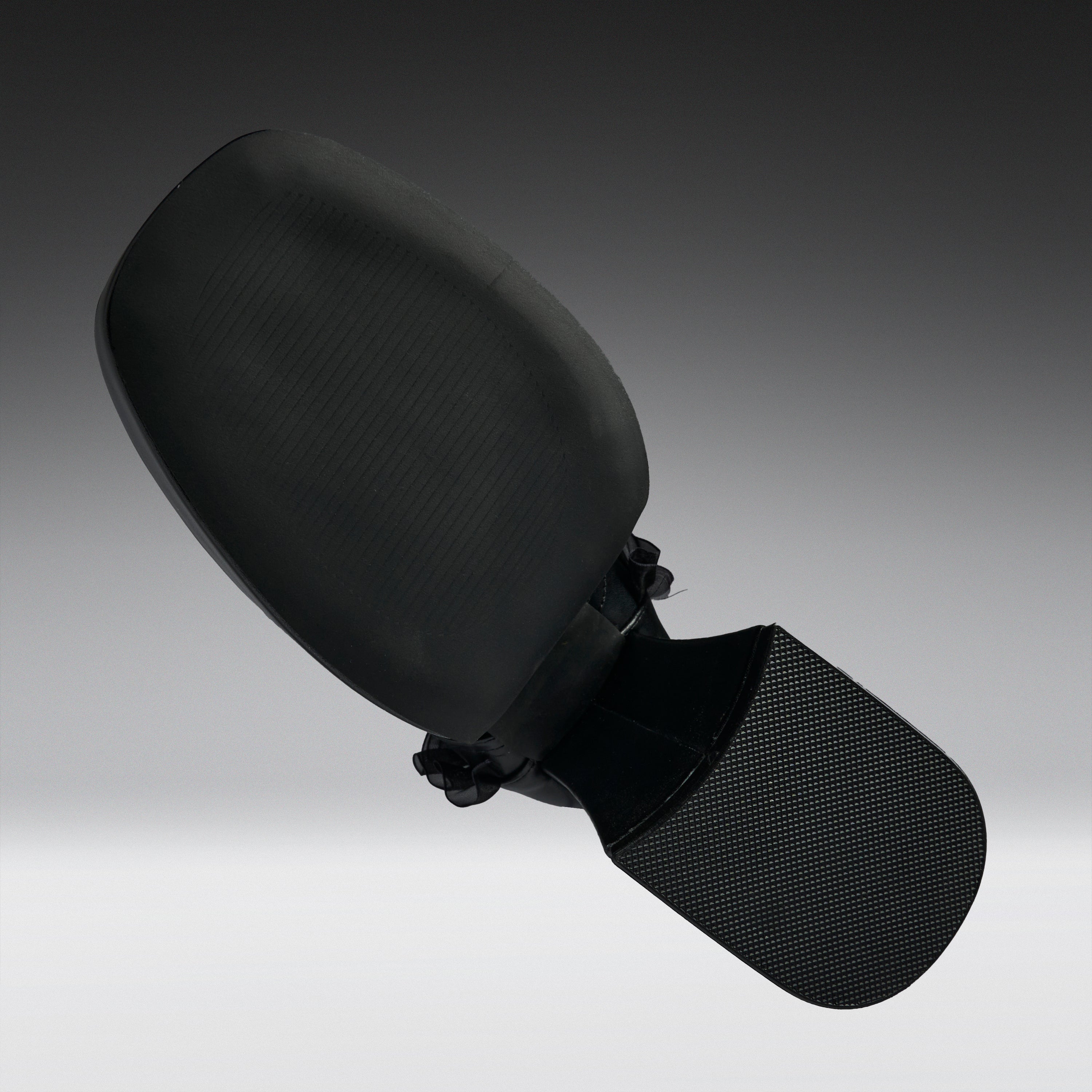 A black car side-view mirror assembly with a textured plastic housing and a mesh-covered mounting bracket, shown against a dark-to-light gray gradient studio background.