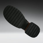 A close-up of a black rubber shoe sole with deep grooves, shown against a gradient gray background.