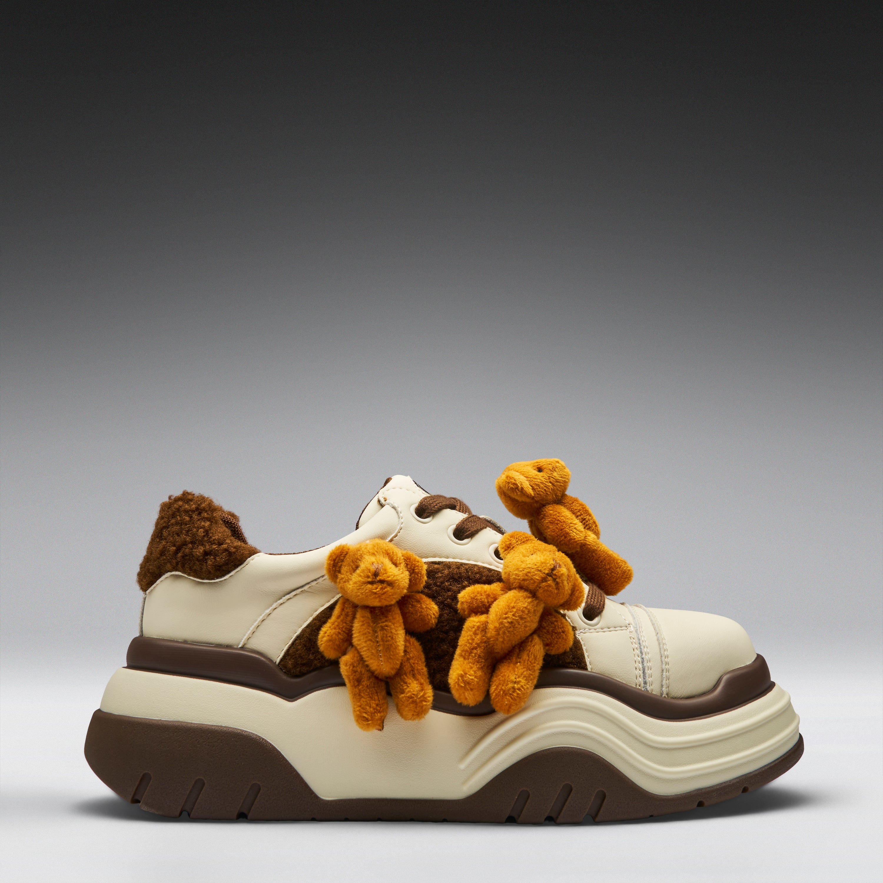 White sneaker with brown and beige teddy bear decorations on a gray background
