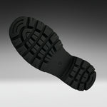 A close-up of a black rubber shoe sole with deep tread patterns, shown against a dark gray to light gray gradient background.