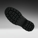 A close-up of a black rubber shoe sole with deep tread patterns, shown floating against a dark-to-light gray gradient background.