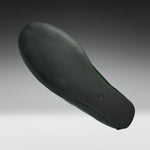 A single shoe sole shown floating against a dark-to-light gray gradient background. The sole is dark charcoal gray with a subtle green tint along the inner edge.