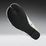 A split-foot flat sandal shown from the sole view, featuring a black textured midfoot and heel with a white and black ant-patterned outsole, set against a dark-to-light gray gradient background.