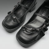 A pair of black Mary Jane-style shoes with textured spiral embellishments on the straps, shown on a neutral gray background. The brand name 'IOKZO' is visible on the insole.