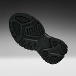 A close-up of a black athletic shoe's textured outsole, shown from a side angle against a dark-to-light gray gradient background.