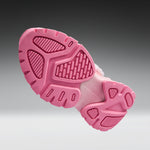 A close-up of a pink shoe sole, showing the textured tread pattern and cushioned midsole, set against a dark-to-light gray gradient background.