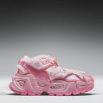 A pink chunky platform sneaker with faux fur trim and glossy pink straps, shown in a side profile against a gray gradient background.