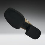 A black motorcycle or bicycle handlebar grip cover with a textured black rubber face and a camouflage-patterned stem section, shown against a dark gray gradient background.