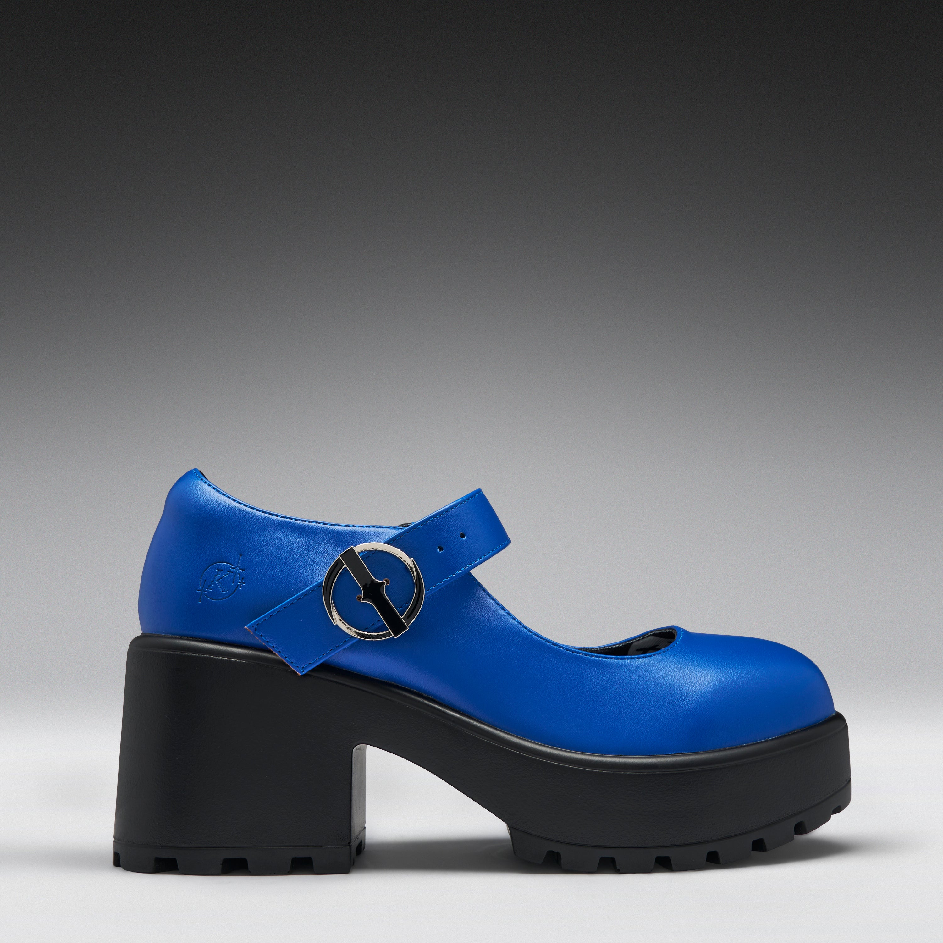 A bright blue Mary Jane style platform shoe with a chunky black block heel and sole, featuring a strap with a circular silver buckle detail.