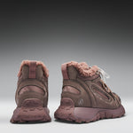Pair of brown winter boots with pink fur lining on a gray background