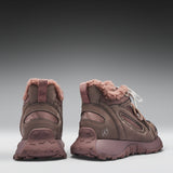 Pair of brown winter boots with pink fur lining on a gray background