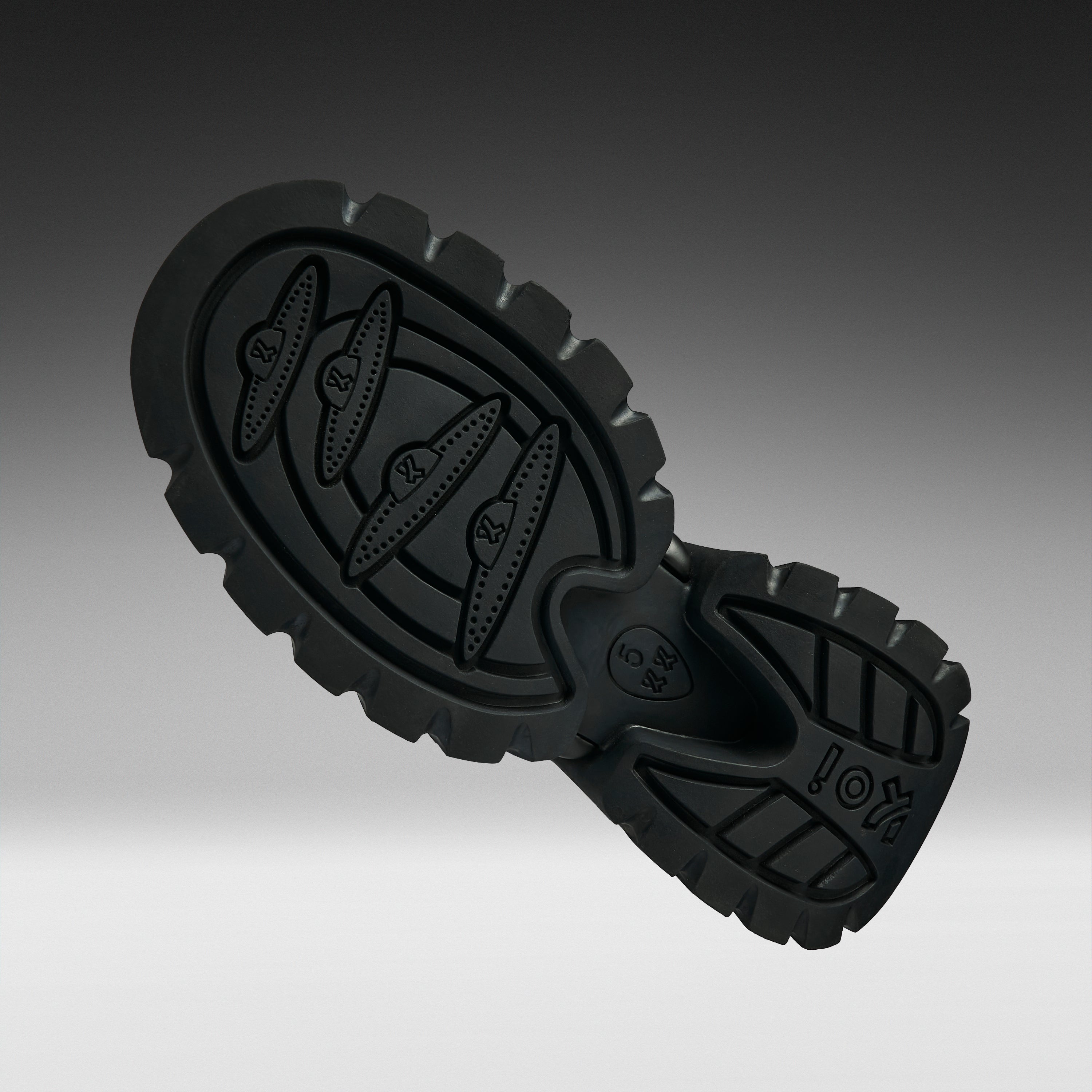 A close-up of a black rubber shoe sole with textured tread patterns and embossed branding, shown against a dark-to-light gray gradient background.