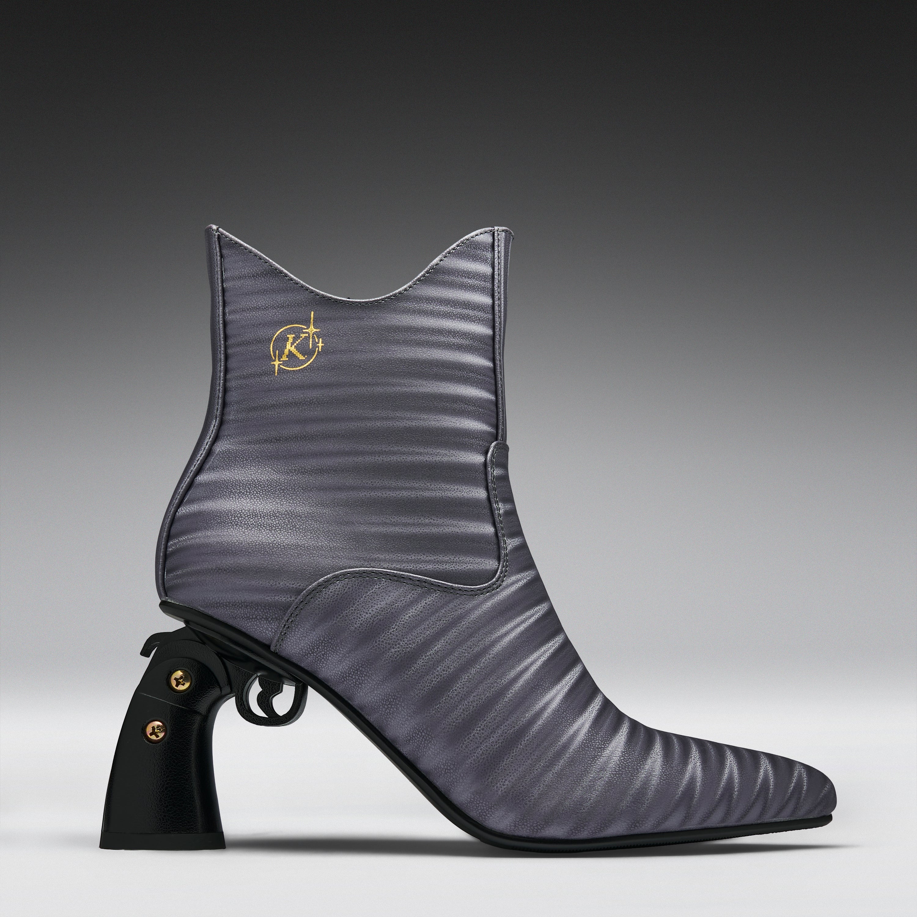 A single women's ankle boot in a textured, ribbed gray-purple leather with a black gunmetal-style heel and gold-tone hardware, shown against a dark-to-light gray gradient studio background.